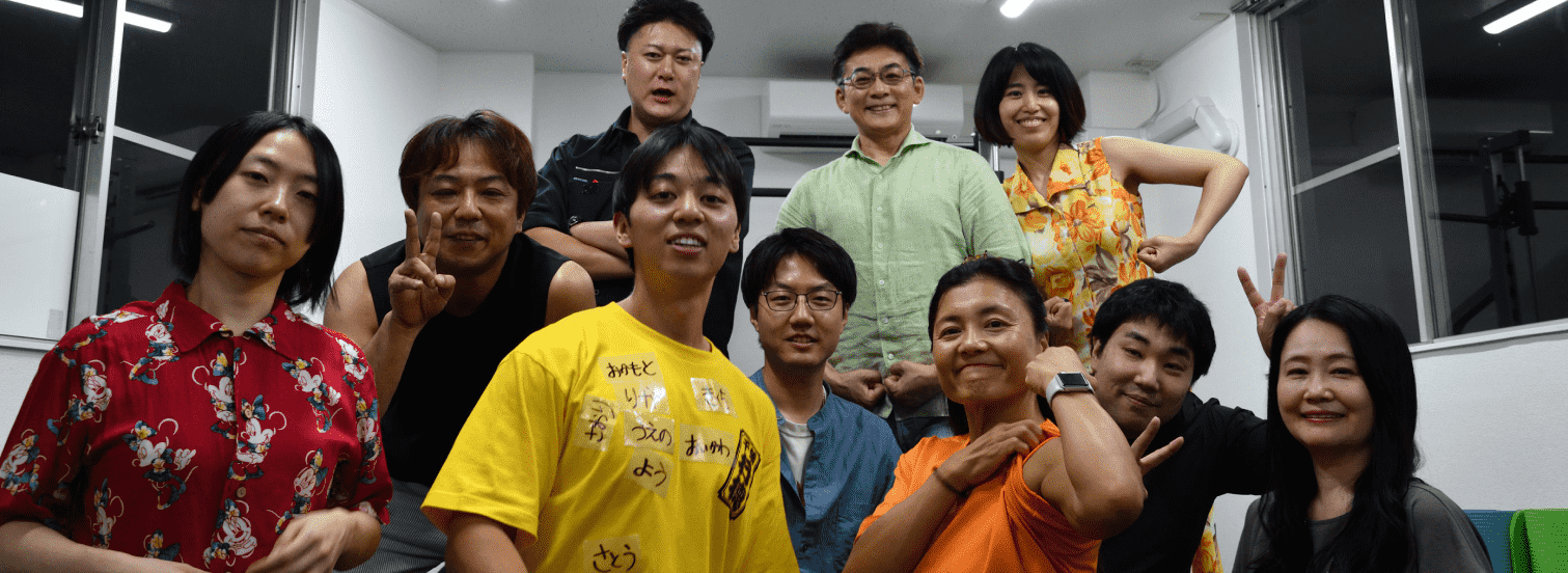 公式サイト掲載の集合写真。トレーニングスペースに集まる人たち